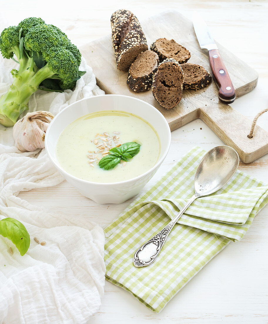 Broccoli cream soup with sunflower seeds, fresh basil and bread