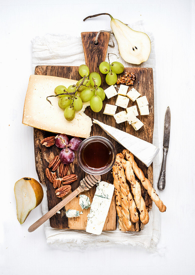 Cheese appetizer set - Various types of cheese, honey, grapes, pear, nuts and bread grissini sticks