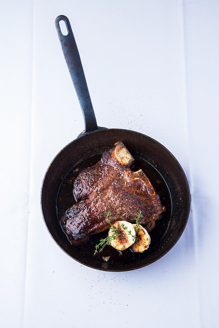 A Porterhouse steak in a pan