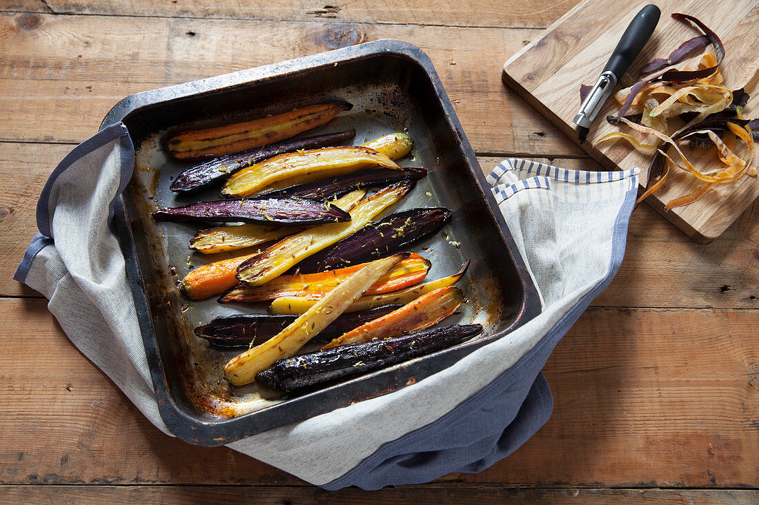 Roasted heritage carrots with lemon and cumin in a baking tray