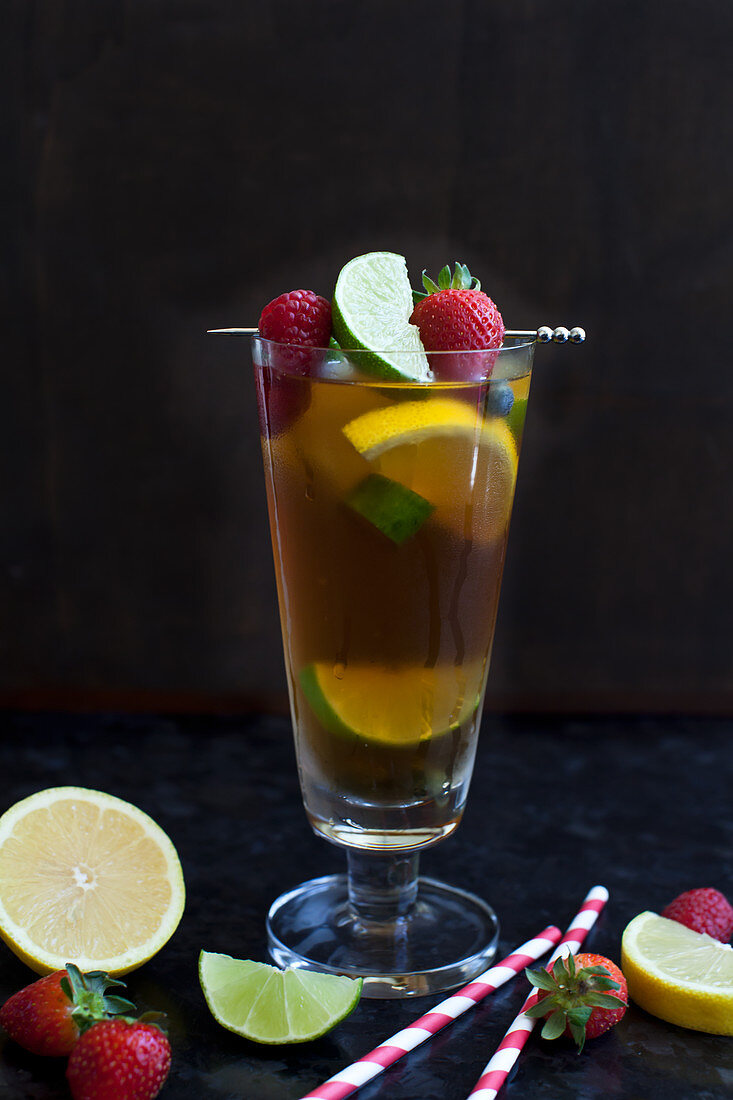 Ein großes Glas Pimms mit Limette und Himbeere