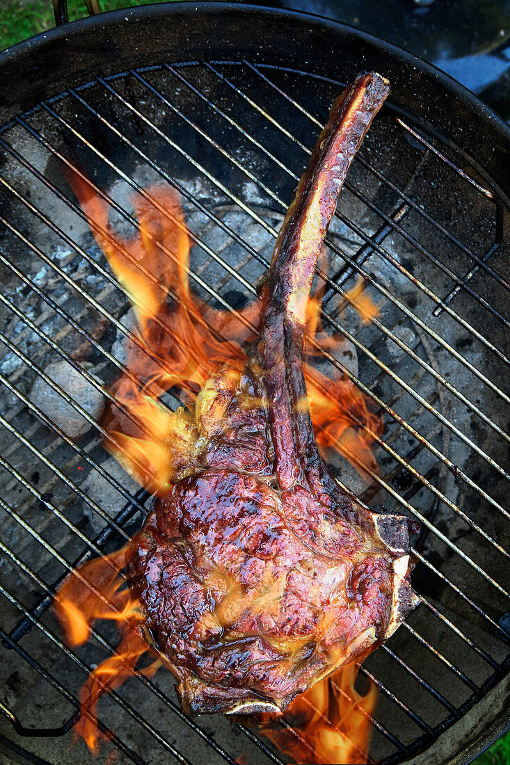 Tomahawk beef steak on a grill (top view)