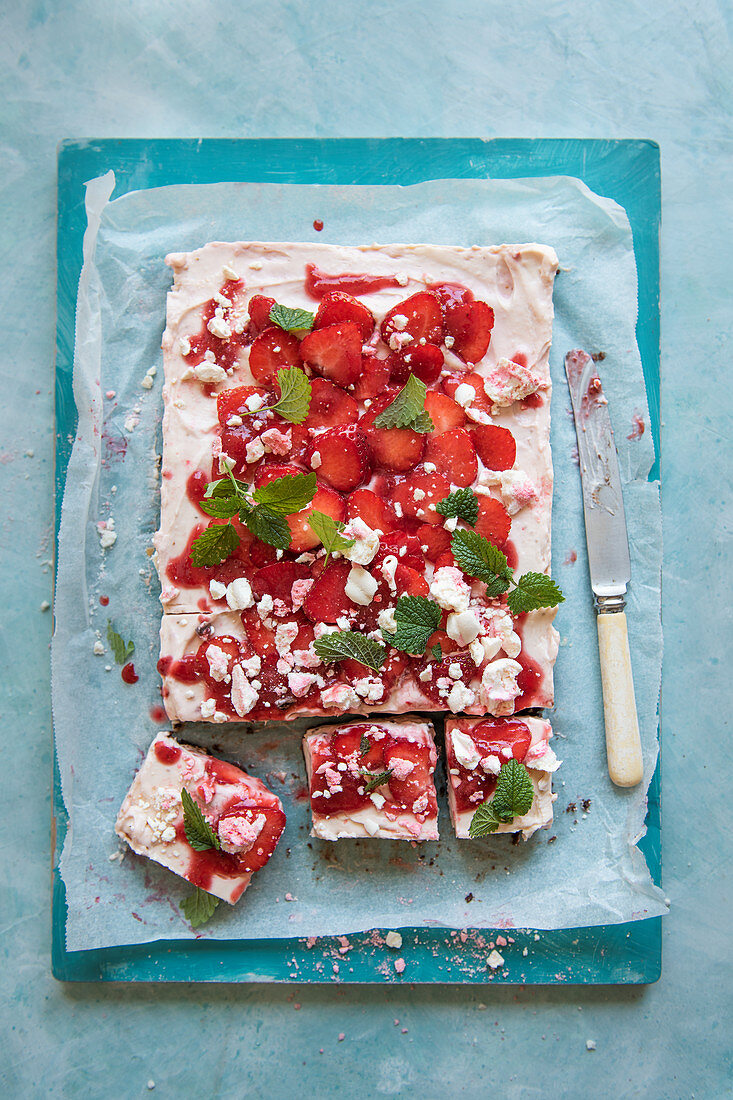 Strawberry cheesecake with fresh strawberries, crushed meringue and mint