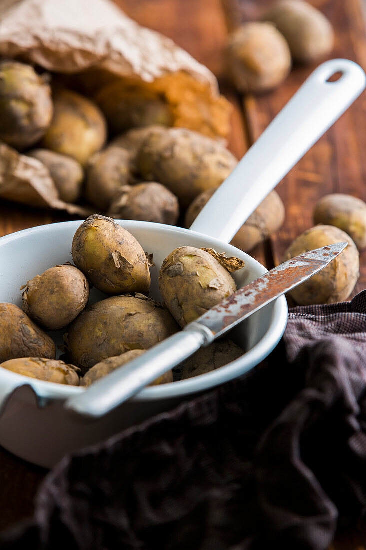 Neue Kartoffeln im Sieb mit Messer