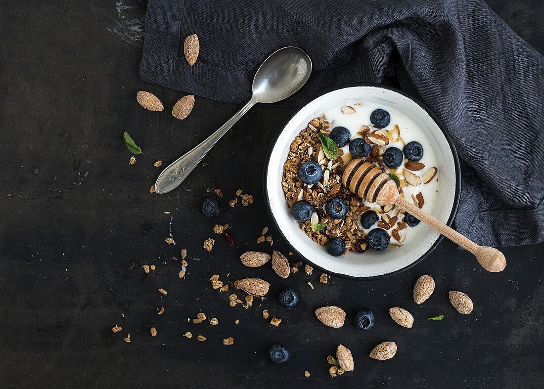 Healthy breakfast - Oat granola with fresh blueberries, almond, yogurt and mint