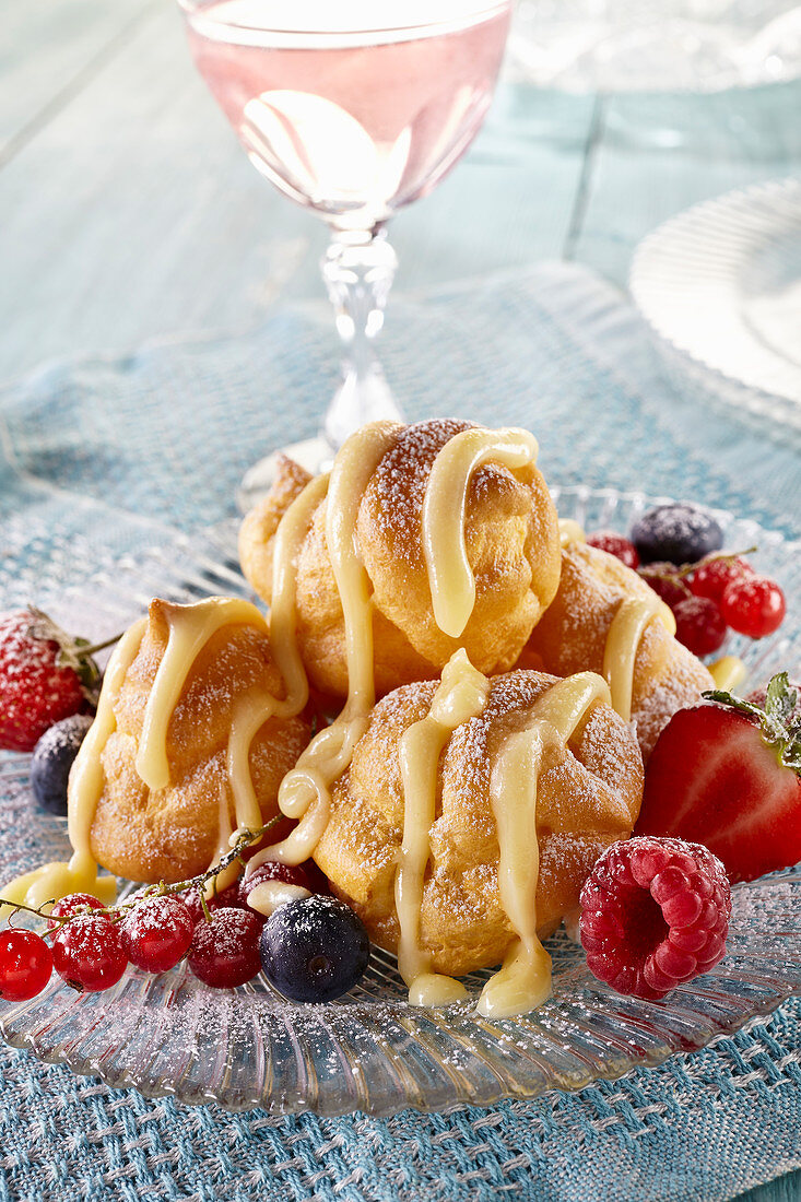 Profiteroles with berries and white chocolate sauce