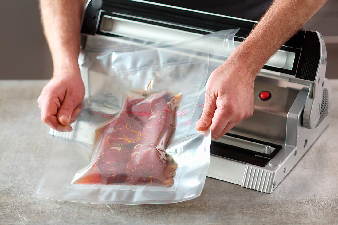 Meat being vacuum packed in a double bag