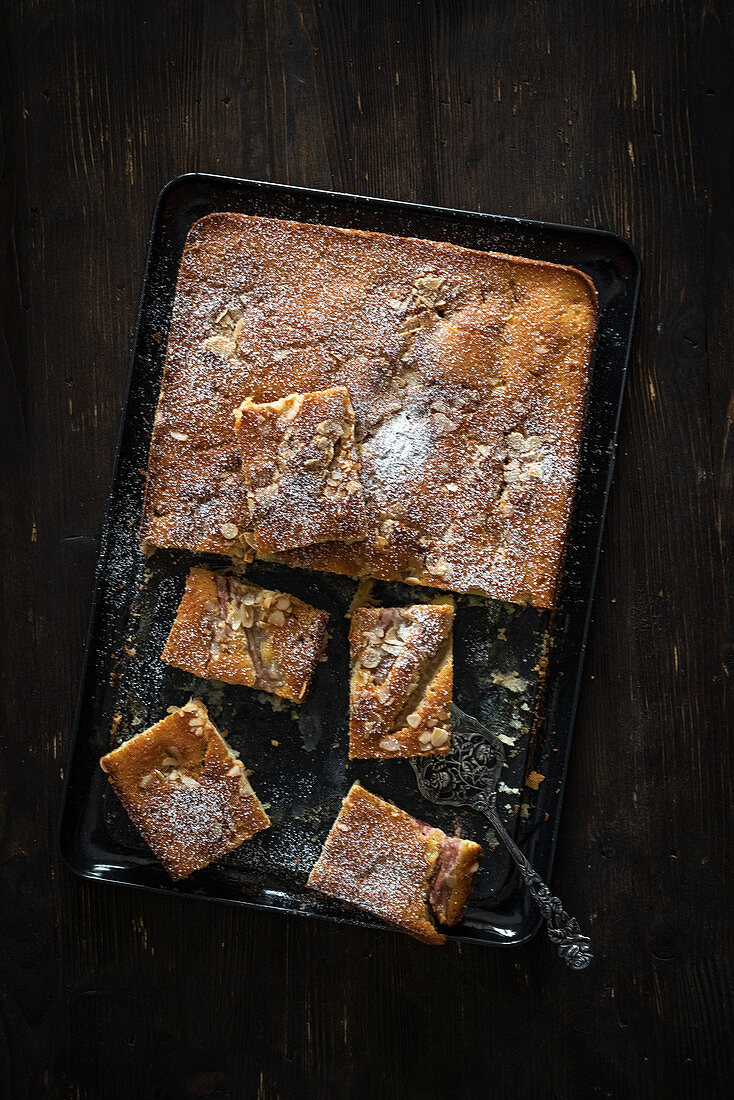 Tray bake cake with flaked almonds and icing sugar