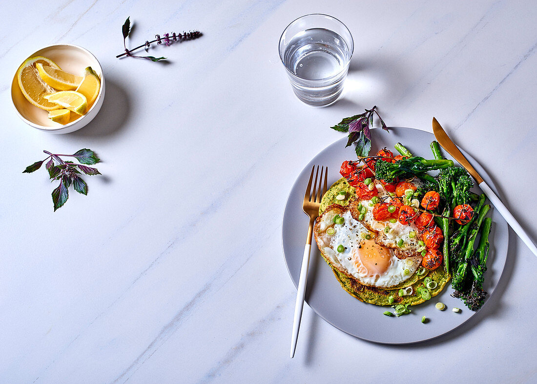 Grüne Kichererbsenpfannkuchen mit Spiegeleiern, Broccolini und Rispentomaten