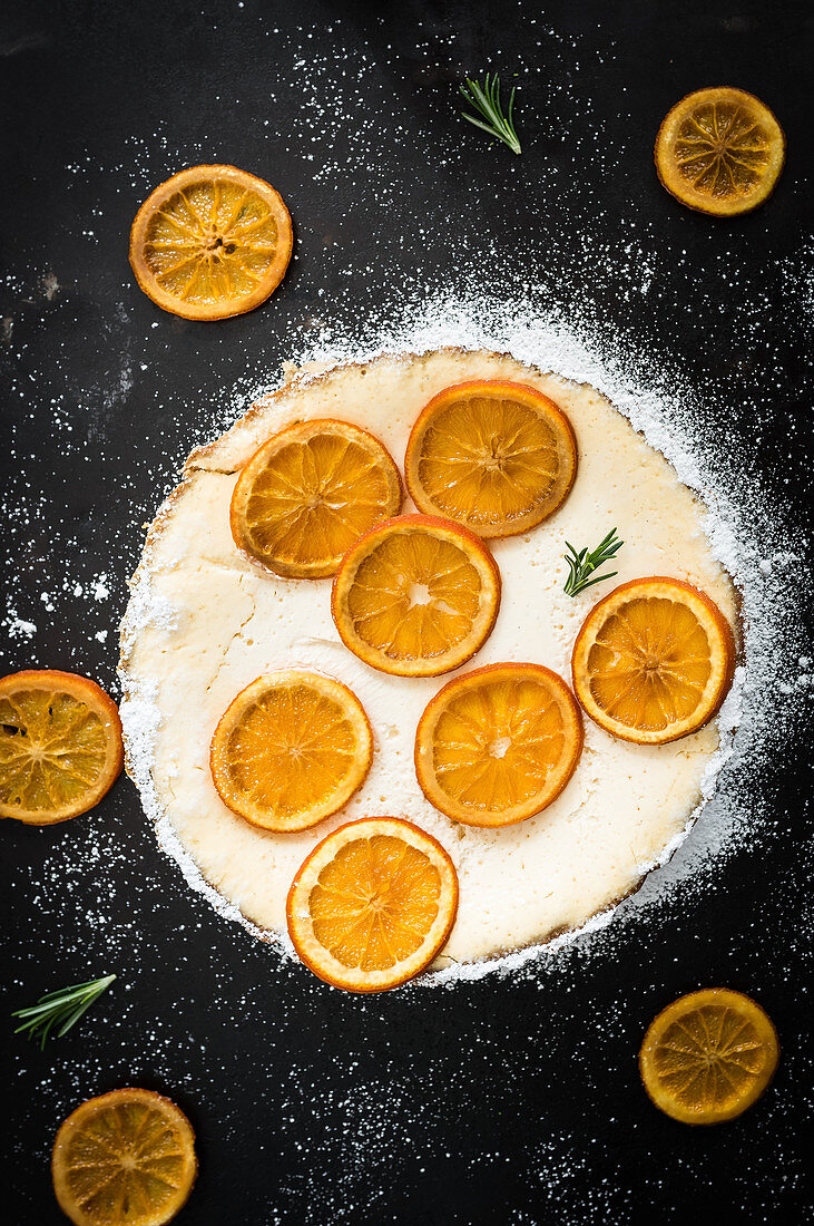Orangentarte mit Orangenscheiben, Joghurtcreme, Rosmarin und Puderzucker