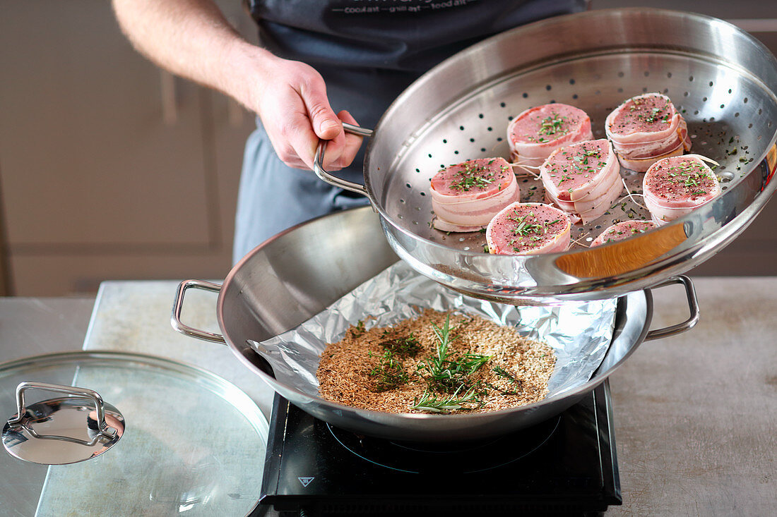 Barded saddle of pork being smoked in a hot wok