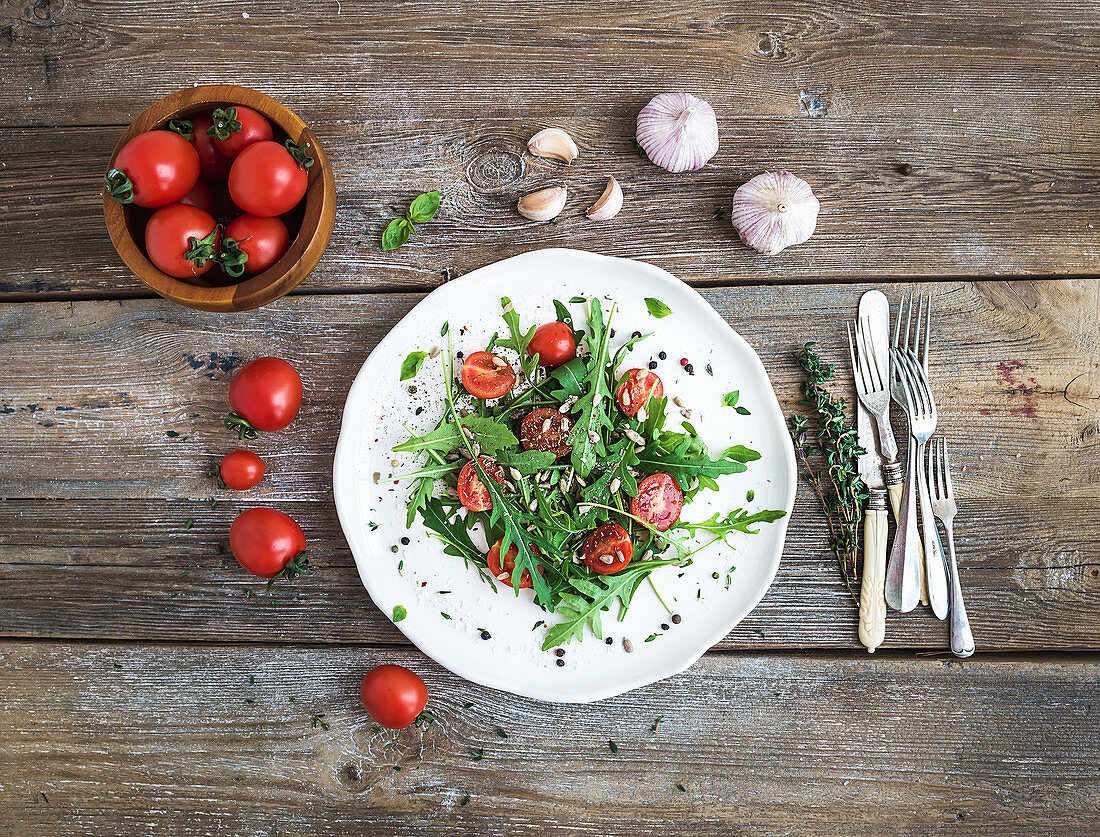 Salad with arugula, cherry tomatoes, sunflower seeds and herbs