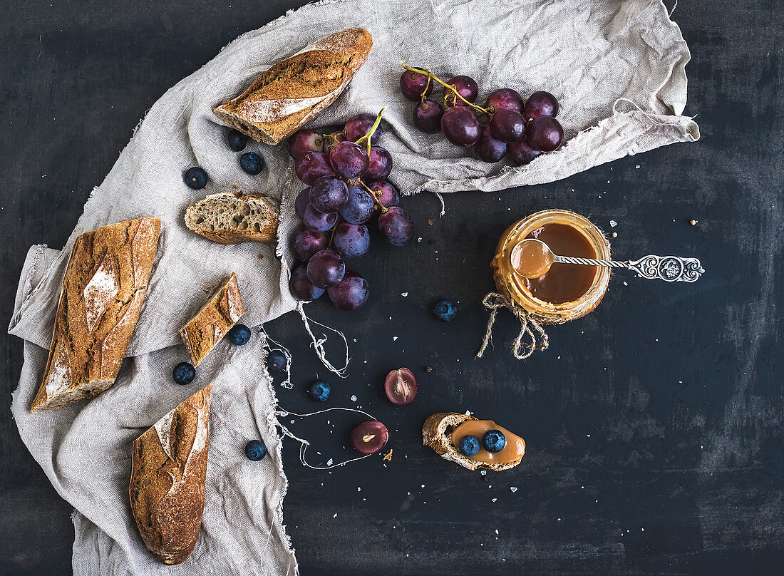 French baguette cut into pieces, red grapes, blueberry and salty caramel sauce