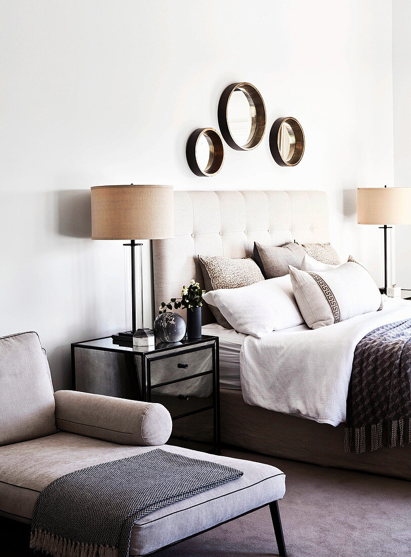 Bedside table with lamp between day bed and double bed in the bedroom