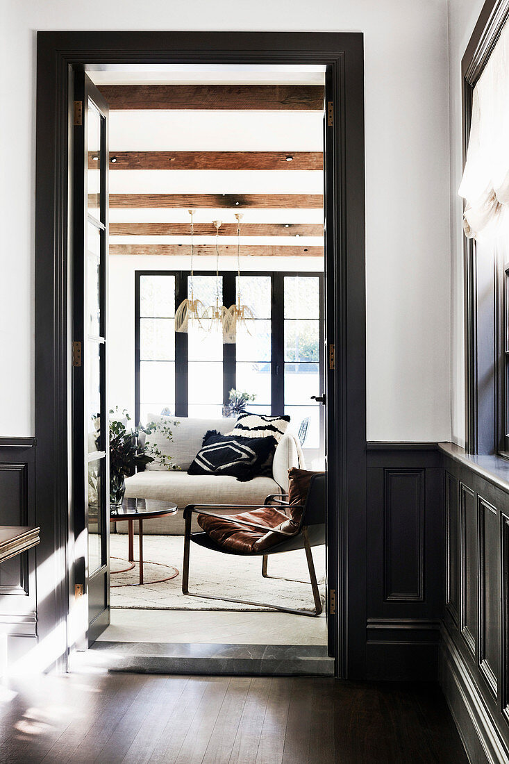 View of sofa and armchair in living room through door opening