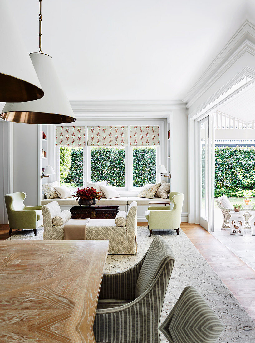 Open living room with dining area and lounge in front of an open patio door