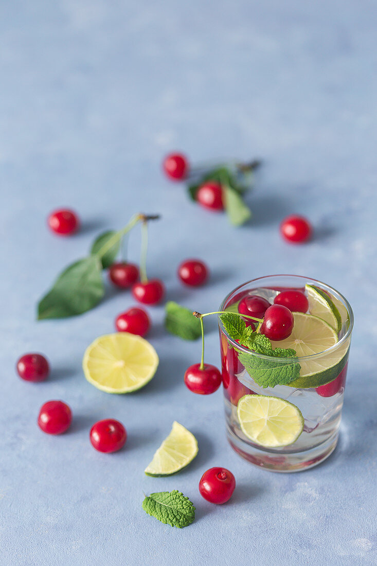 Mojito mit Kirschen, Limettenscheiben und Minze