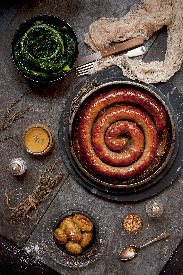 Cumberland-Wurst mit Hasselbackkartoffeln, Senfsauce und Cavolo Nero