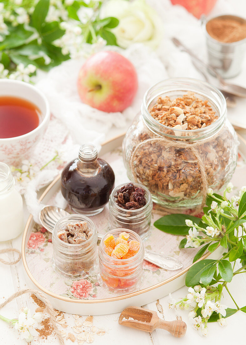 Tablett mit getrockneten Früchten, Sirup und hausgemachtem Apfel-Müsli