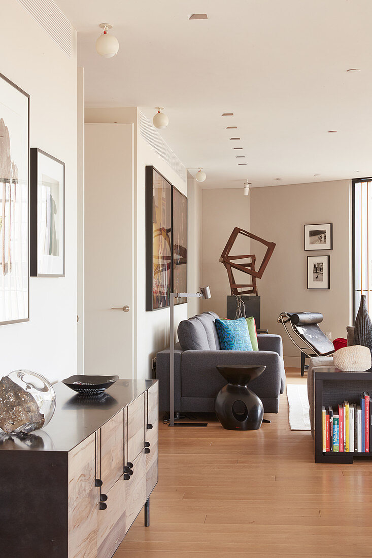 View past sideboard into open-plan living area with grey sofa