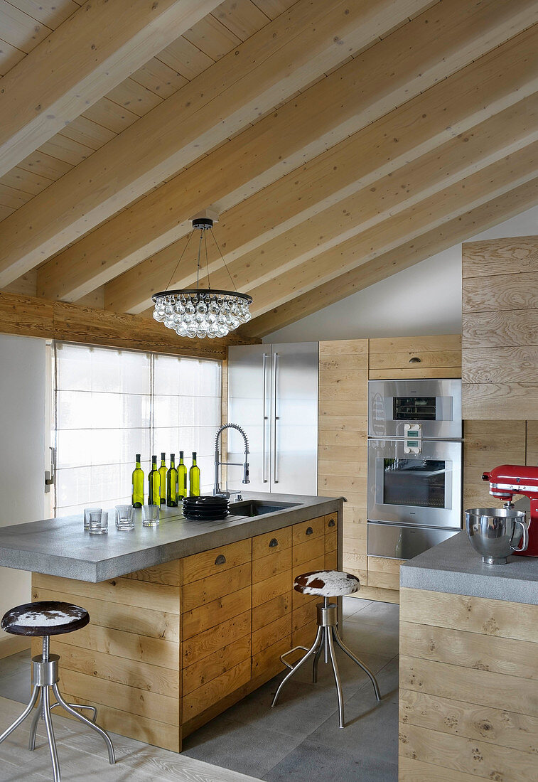 Modern kitchen with wooden cabinets and concrete worksurface in chalet