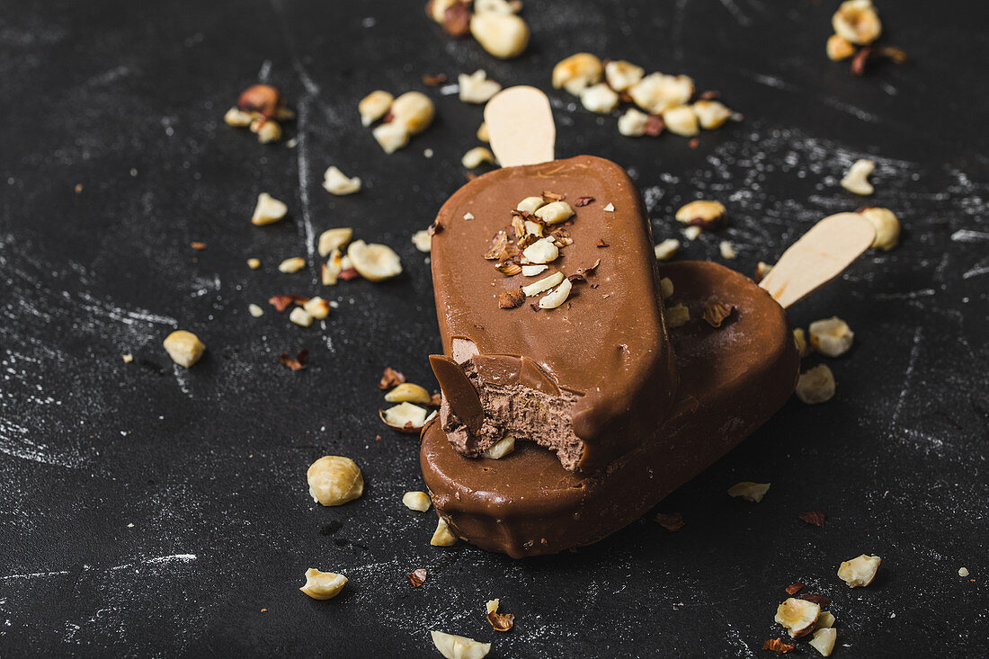 Two chocolate ice cream stick with hazelnuts