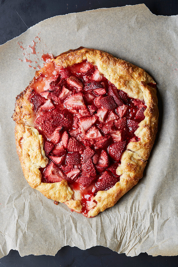 Strawberry tart on baking paper (seen from above)