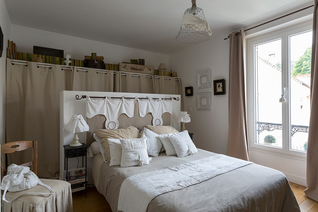 Double bed and walk-in wardrobe in bedroom in natural shades