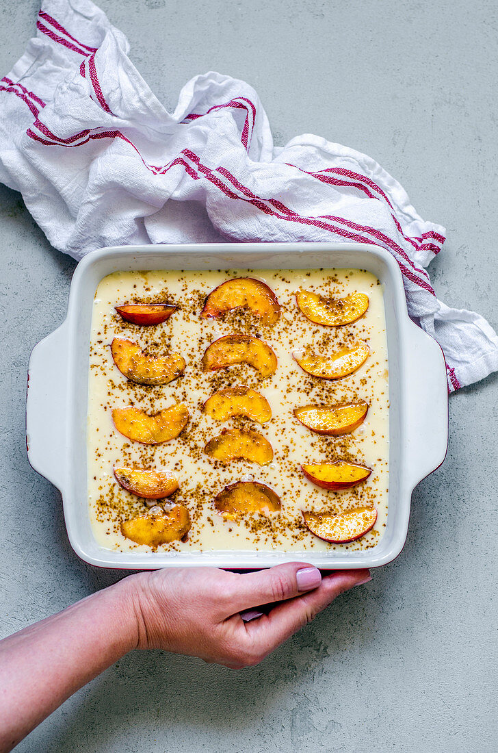 Ungebackener Pfirsich-Clafoutis in einer Auflaufform