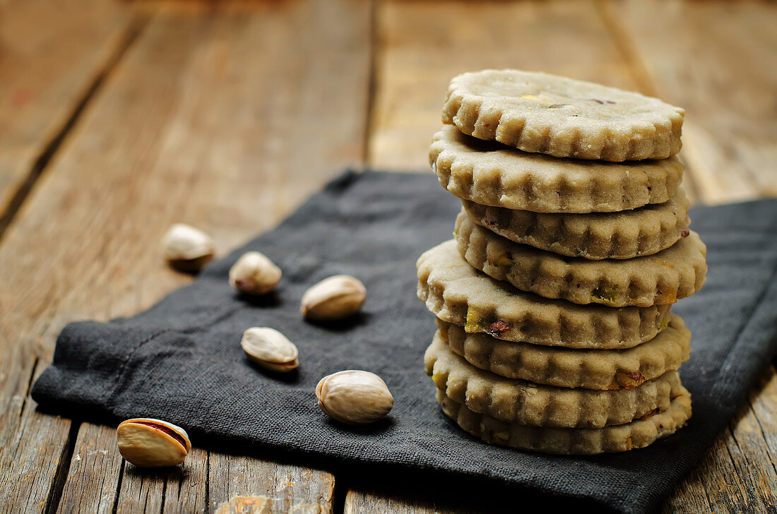Cashew butter cookies with pistachios on a wood background