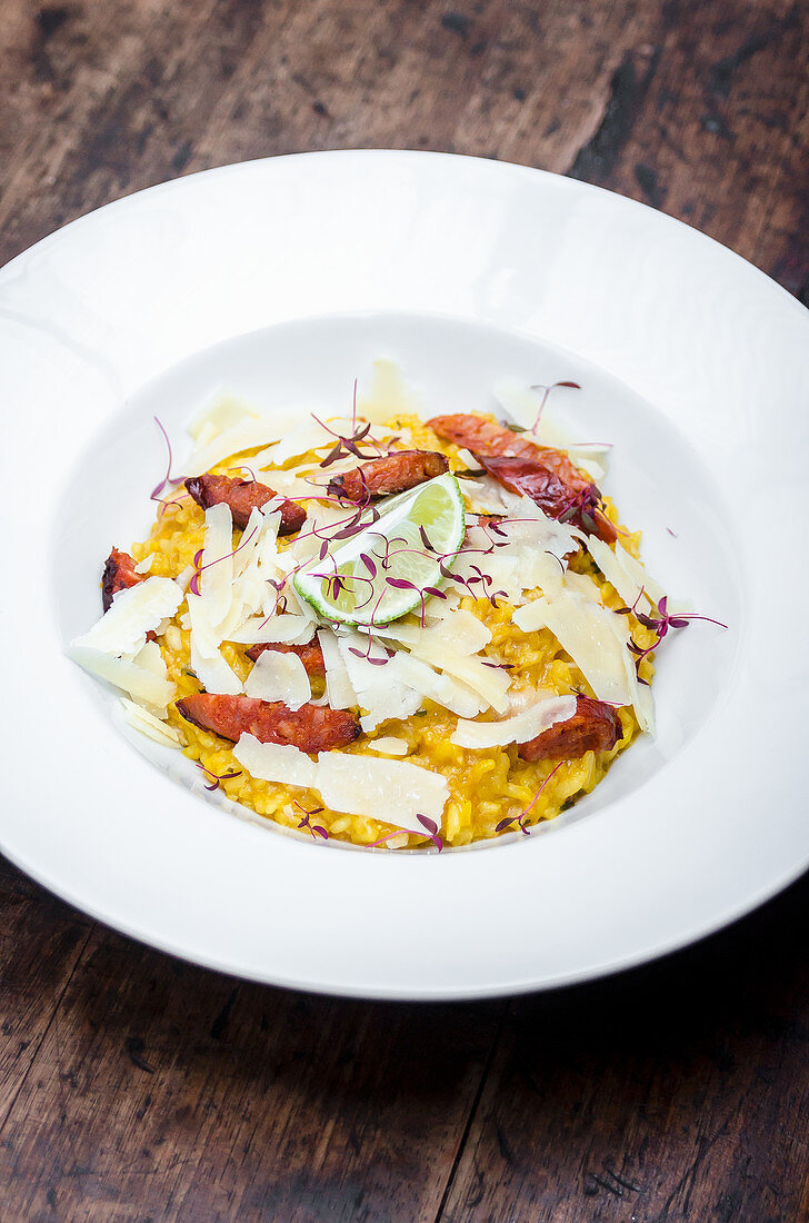 Plate of saffron risotto with chorizo sausage and parmesan shavings
