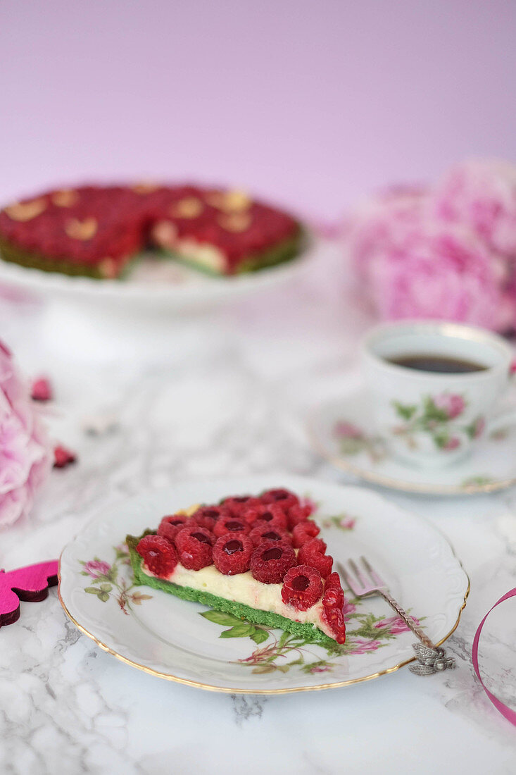 A raspberry tart with a green base and vanilla cream