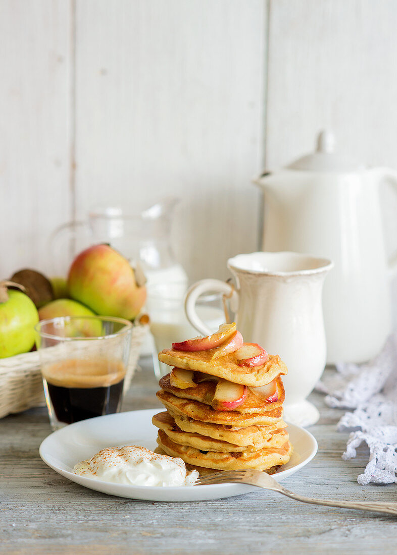 Apfel-Pancakes mit Sahne auf Teller gestapelt