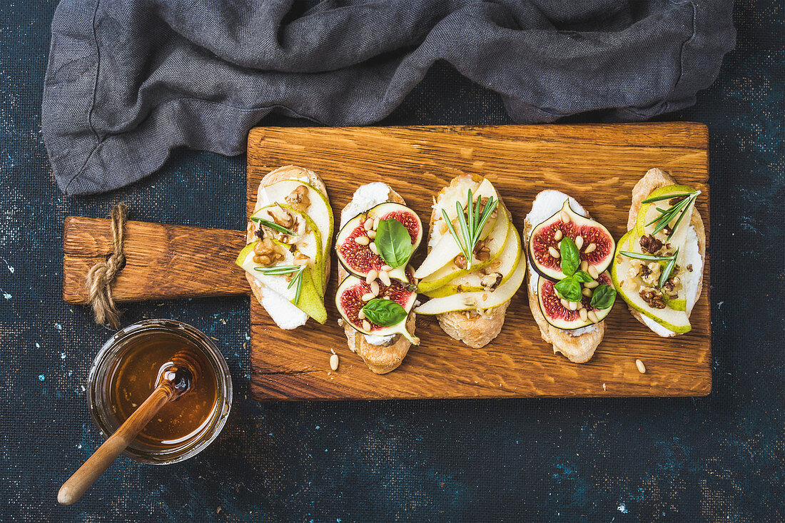 Breakfst crostini with pear, ricotta cheese, honey, figs, nuts and herbs