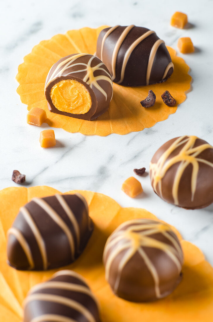 Chocolate pralines filled with caramel on a marble background