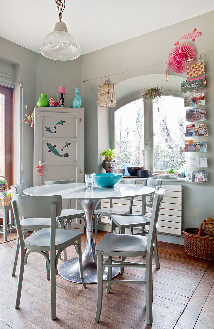 Round table, wooden chairs and corner cupboard in kitchen