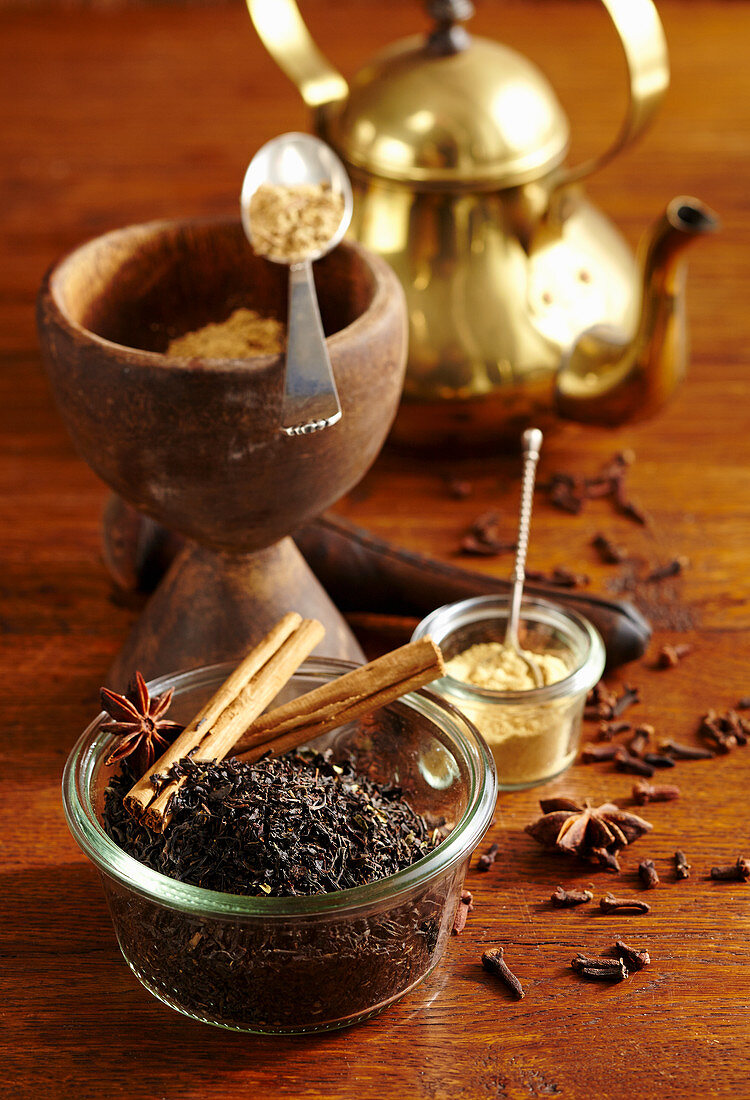 an arrangement of spices with a golden teapot