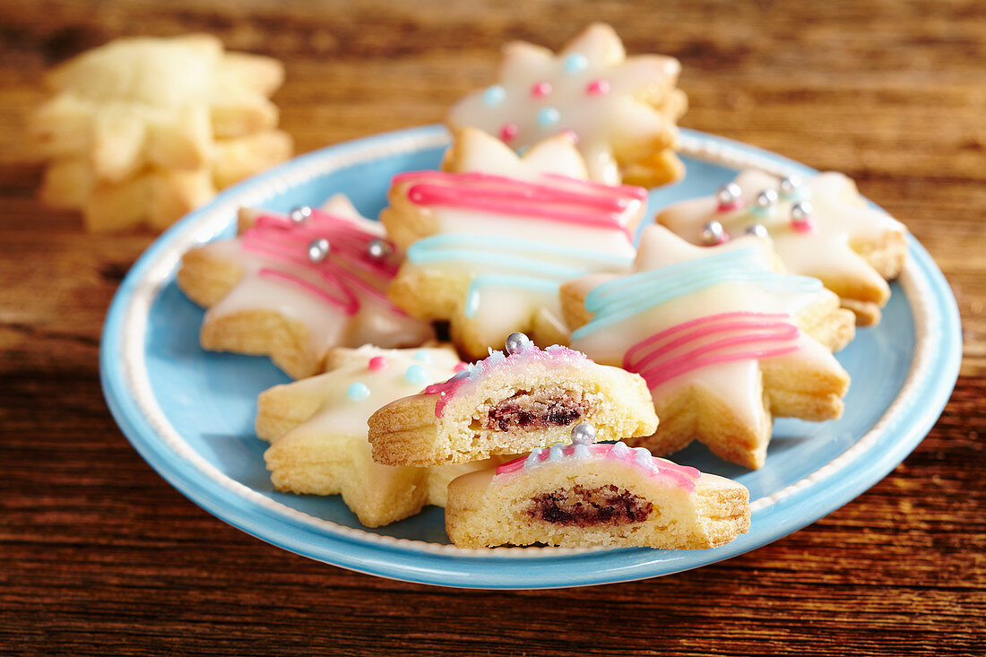 Colourful star biscuits with icing and filled with jam