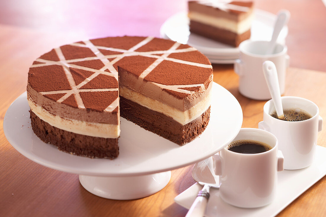 Dreifarbige Schokoladenmousse-Torte mit Kakao-Muster