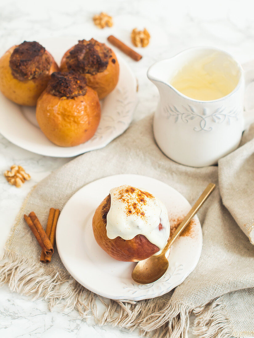 A baked apple filled with dates and walnuts served with yoghurt