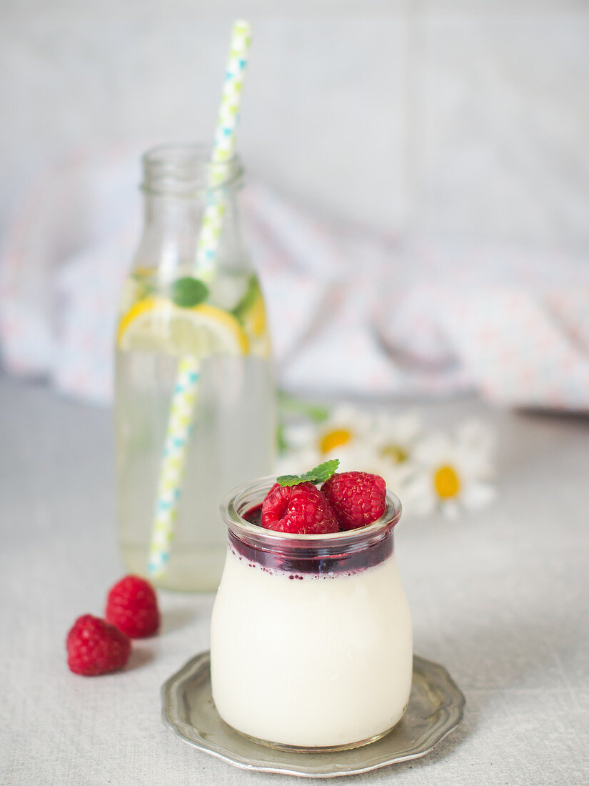 Holunderblüten Panna Cotta serviert mit Himbeersauce und Himbeeren