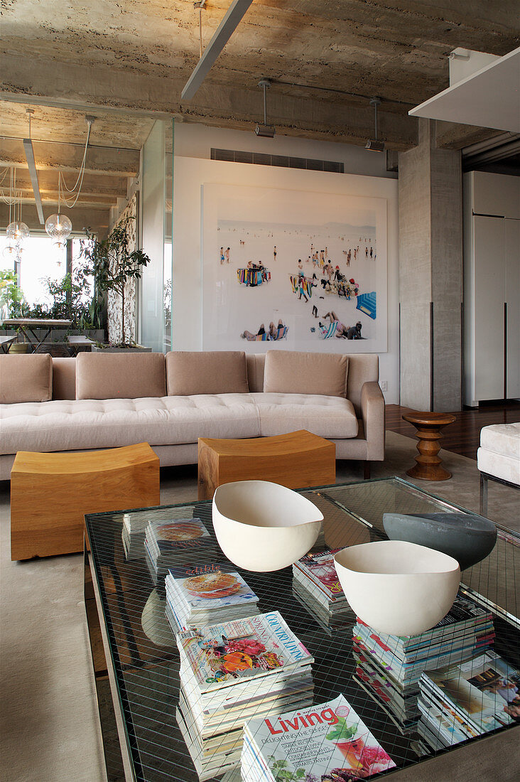 Magazines and bowls on glass coffee table in elegant lounge