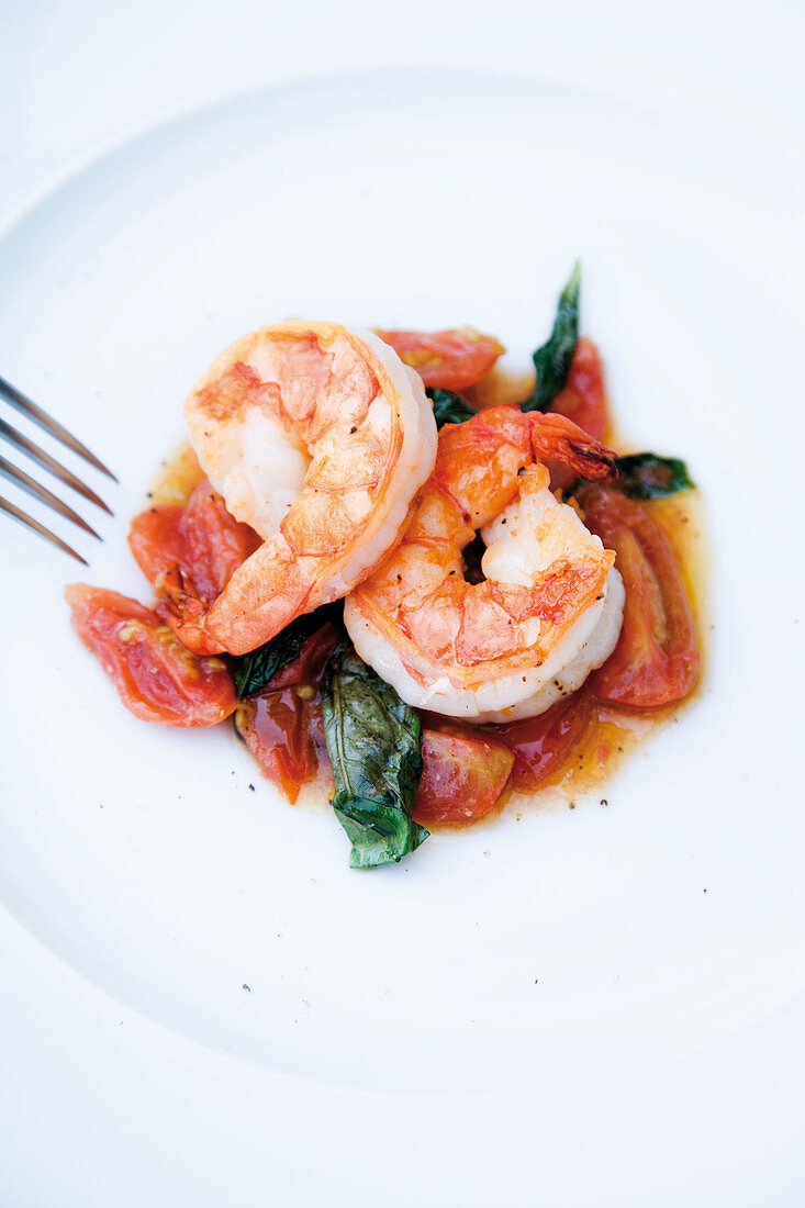 Roasted king prawns on cherry tomatoes with basil