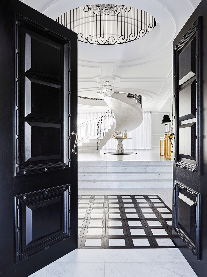 Glance into elegant hall with marble tiles and spiral staircase