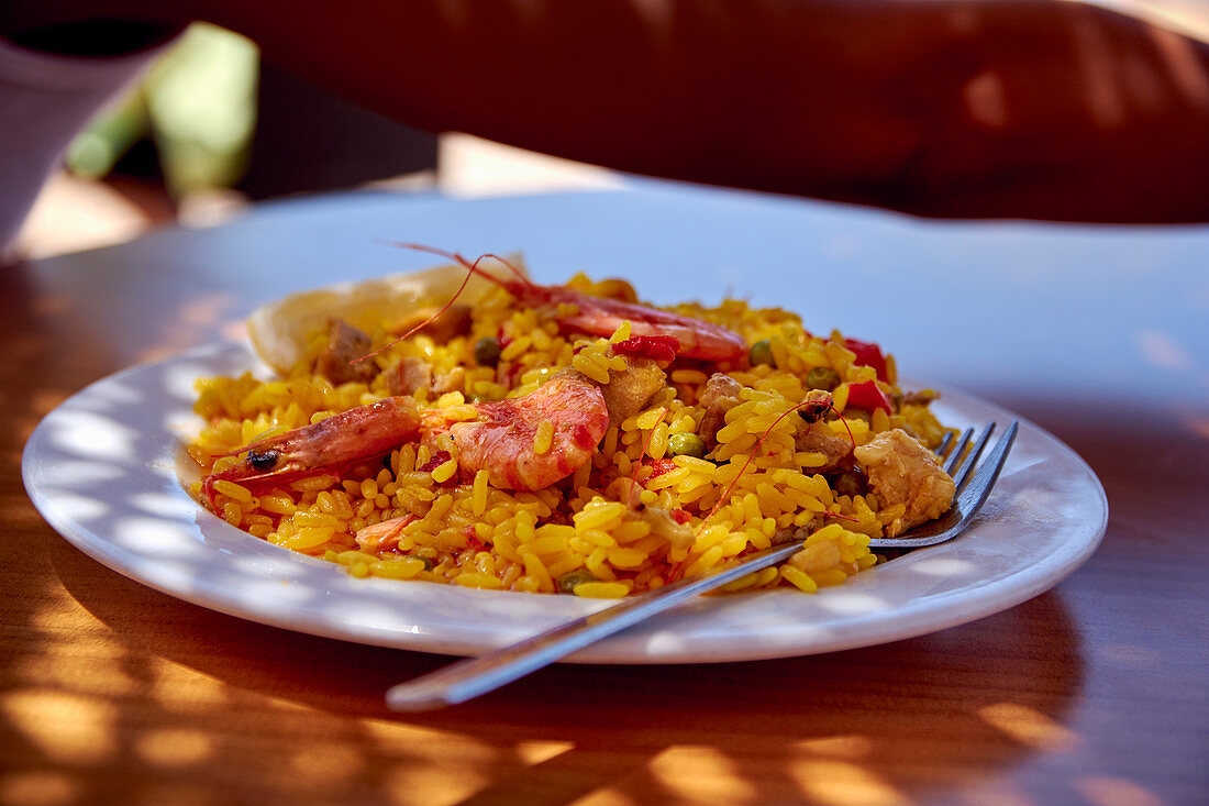 Paella with prawns on a table outside