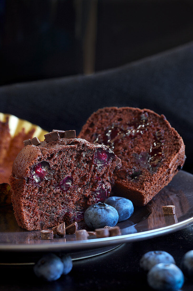 Schokoladenmuffins mit Blaubeeren, halbiert (Nahaufnahme)