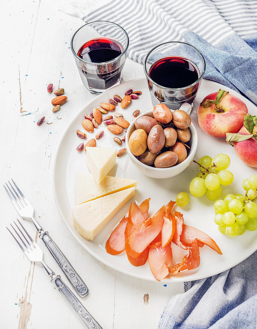Wine snack set - Cheese, chicken carpaccio, mediterranean olives, fruits, nuts and two glasses of red wine