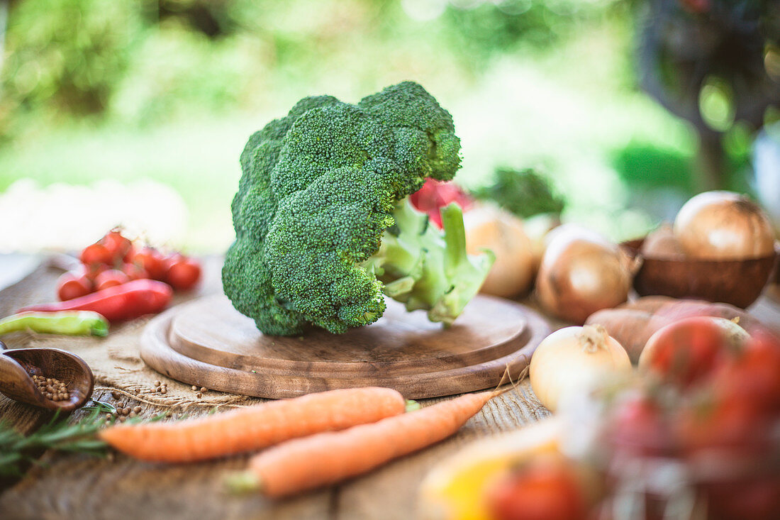 Gemüsestillleben mit Brokkoli auf Holzschneidebrett