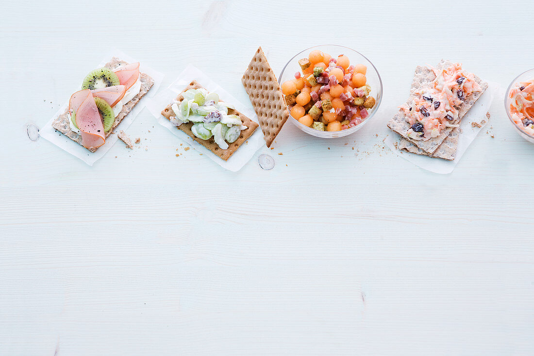 Fruity crispbreads and melon balls with ham cubes