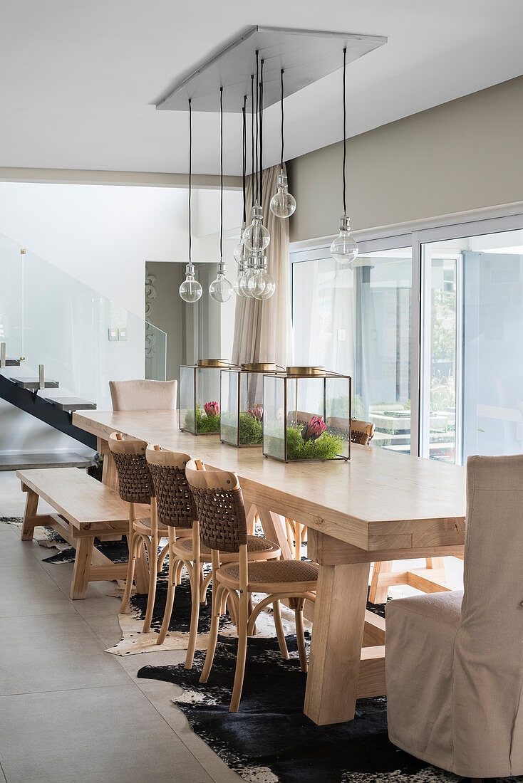 Long, solid-wood table with various chairs and bench